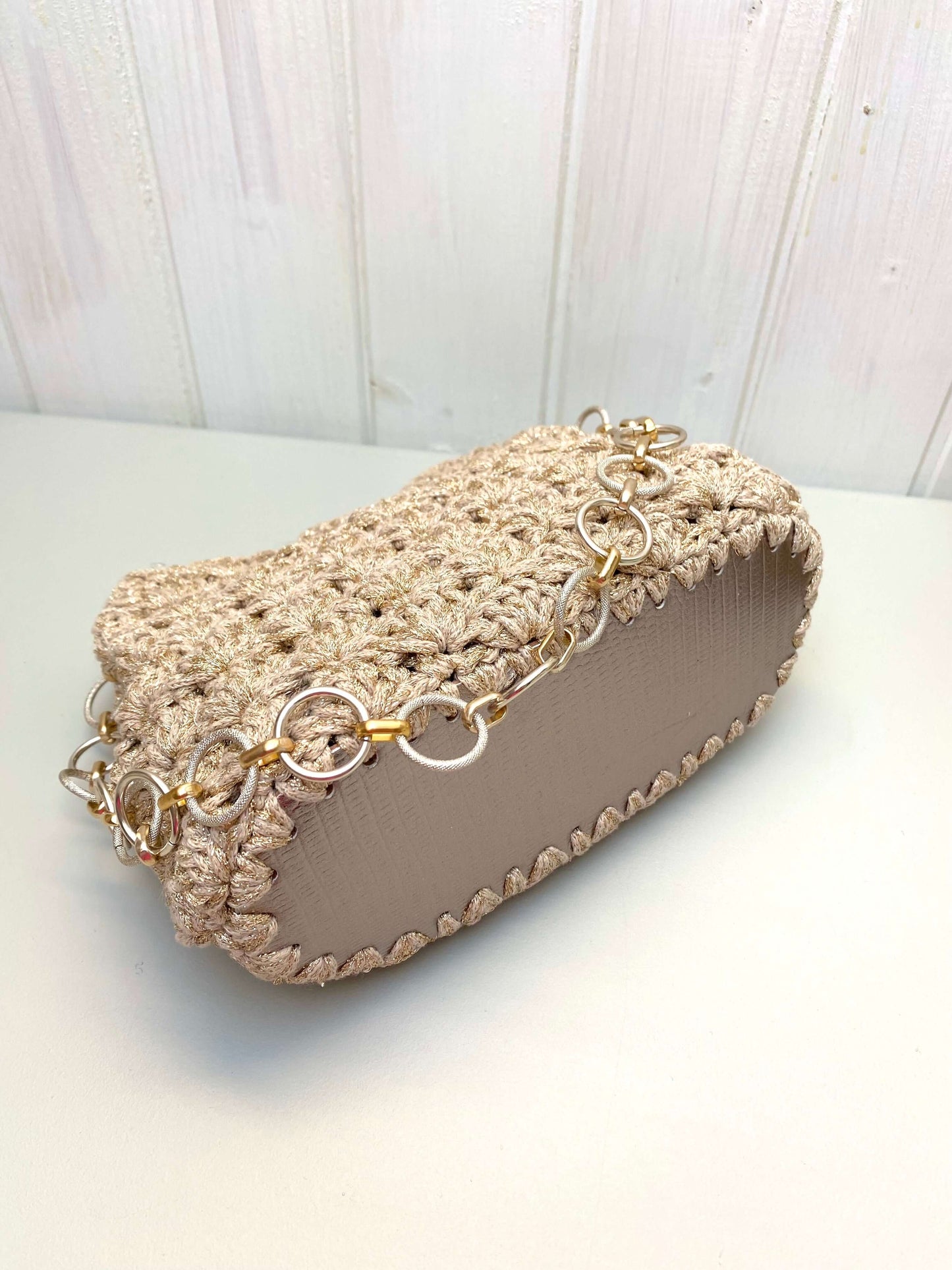 Borsa uncinetto Kira beige dorato piccola vista laterale con dettagli in catena e lavorazione a uncinetto.