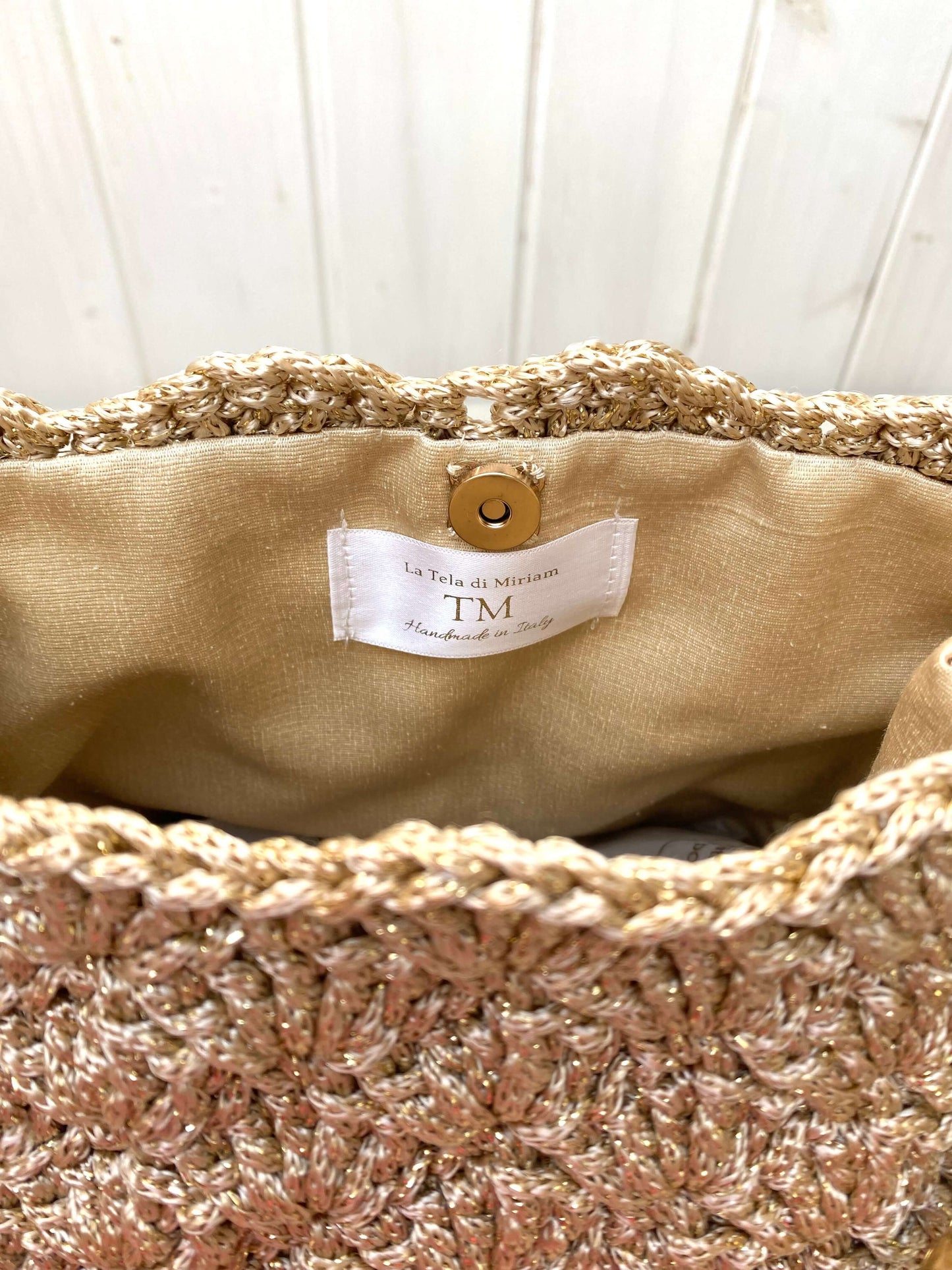 Interno della Borsa uncinetto Kira beige dorato con foderatura pregiata e chiusura a bottone.