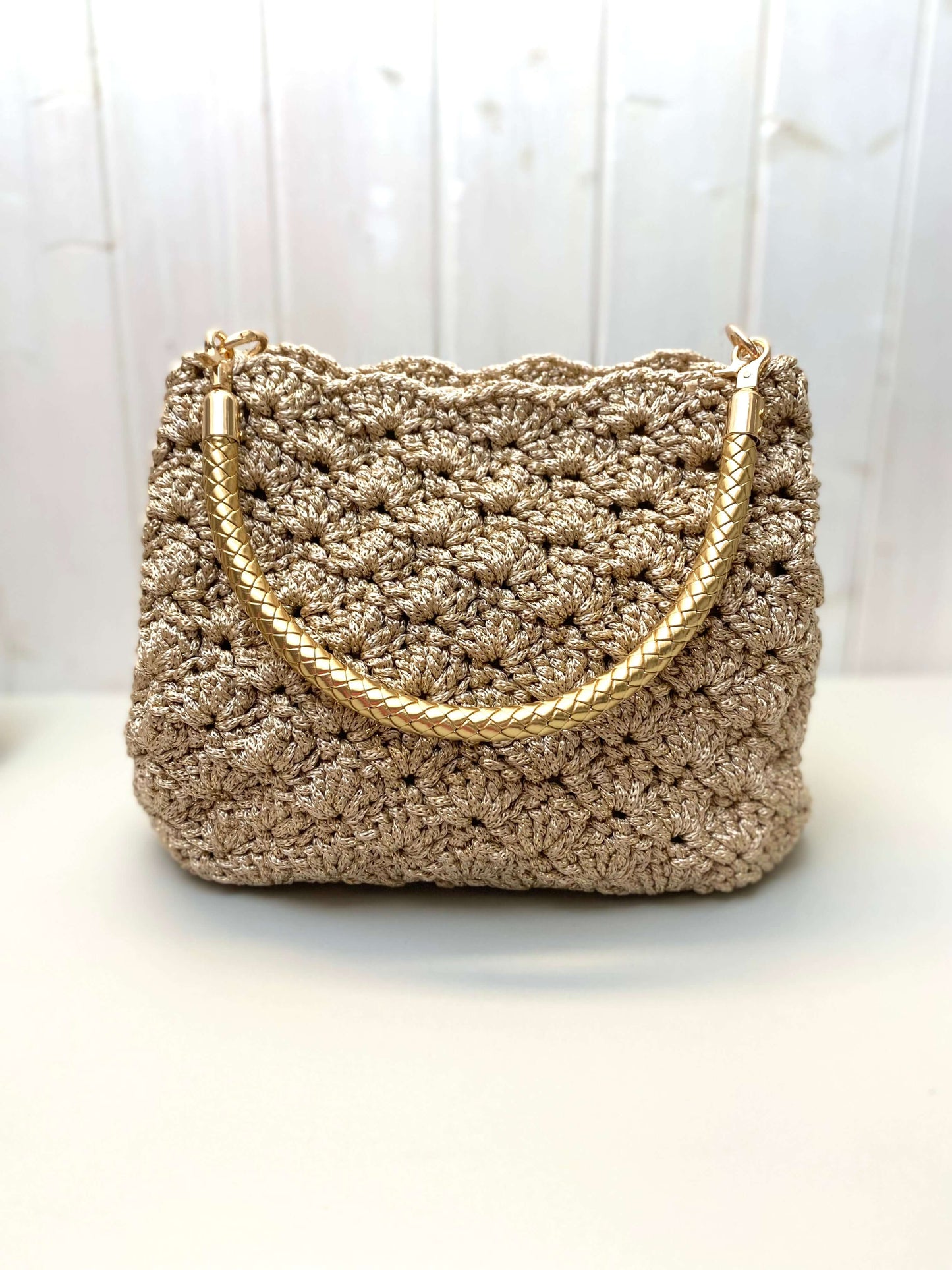 Borsa uncinetto Kira beige dorato con manico dorato in cordino, realizzata a mano con elegante tessitura.