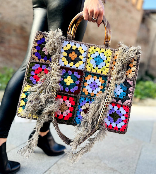 Borsa uncinetto granny Aurora Vintage indossata con catena e pelo icona di eleganza